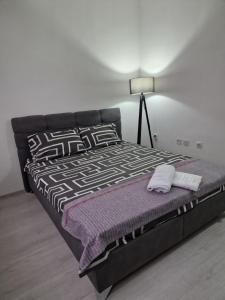 a large bed in a bedroom with a lamp at M and M Apartment in Ohrid