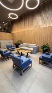 a lobby with blue chairs and tables and a couch at Hotel Estilo MB - Mar del Plata in Mar del Plata