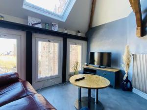 una sala de estar con un sofá y una mesa en La TOUR, en Rodez