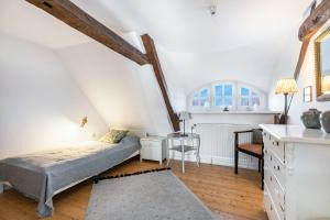 a attic bedroom with a bed and a desk at Reetdachhof Familie Dührsen in Norddeich