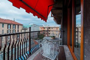 a balcony with a table and an umbrella at LovelyHouseBraida in Milan