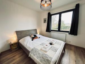 una camera da letto con un letto e una grande finestra di La maison des vignes 3chambres jardin proche Reims a Jonchery-sur-Vesle