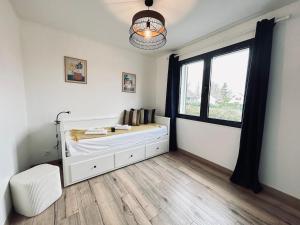 una camera da letto bianca con un letto e una finestra di La maison des vignes 3chambres jardin proche Reims a Jonchery-sur-Vesle Altre 59 foto