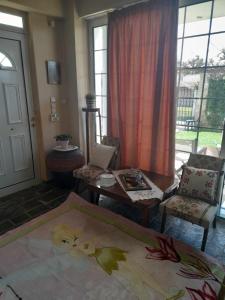 a living room with a bed and a table and chairs at Cozy Christina in Skala Oropou