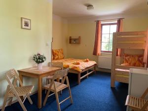 una habitación con una cama, una mesa y sillas en Apartmány Lipka, en Vimperk