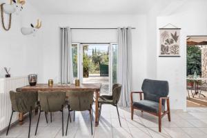 a dining room with a wooden table and chairs at Villa Calma in Pouládes