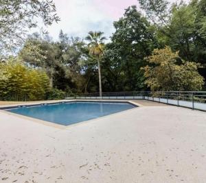 a large swimming pool with a fence around it at Jolie appartement avec piscine et parking privé Menton in Gorbio