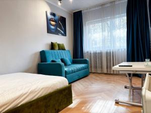 Cette chambre comprend un lit et un canapé bleu. dans l'établissement Camden Flat Walk In Shower, Smart Tv, Queen Bed, à Someşeni