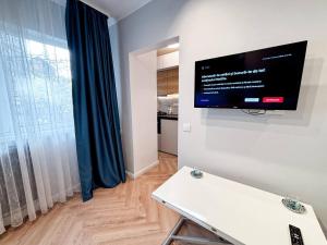 un salon avec une télévision à écran plat au mur dans l'établissement Camden Flat Walk In Shower, Smart Tv, Queen Bed, à Someşeni