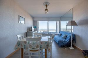 a living room with a table and chairs and a bed at Les Marinas front of the beach in Courseulles-sur-Mer