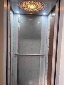 a walk in closet with silver doors and a ceiling at SRI HARI RESIDENCy in Kanipakam +19 photos