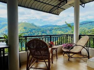 a balcony with chairs and a table with a view at Ella viewpoint sunnyview in Ella