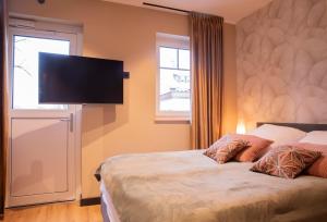 a bedroom with a bed with a flat screen tv on the wall at Residence Vivaldi in Winterberg