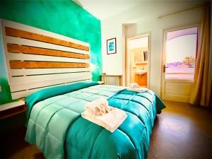 una camera da letto con un letto blu e asciugamani di Albergo 2 Mari a Leuca Altre 37 foto