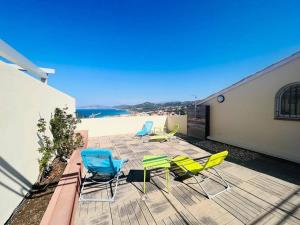 a patio with chairs and a table and a beach at Appartement Le Clos L'ILE ROUSSE in LʼÎle-Rousse