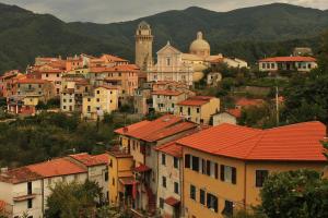 a group of houses and buildings with mountains in the background at Al Vecchio Convento Mare e Monti in Ortonovo