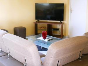 a living room with two chairs and a table with a tv at Maison de vacances Palmier in Sainte-Anne