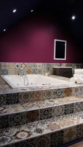a large bath tub in a room with tiles at St Hildas Complex in Hinderwell