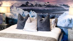 a bed with pillows in front of a snow covered wall at St Hildas Complex in Hinderwell