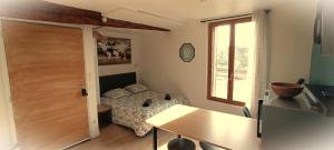 a bedroom with a bed and a table and a window at La Marne in Meaux