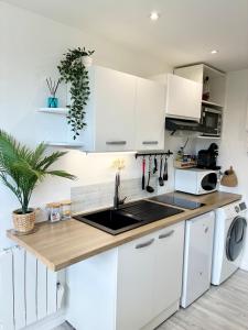 a kitchen with white cabinets and a sink at La Gravière, Cozy Studio Wifi & Parking 20M Océan Surf Plage in Soorts-Hossegor