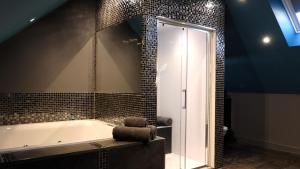a bathroom with a tub and a glass shower at St Hildas Complex in Hinderwell
