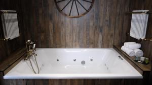 a white bath tub in a bathroom with wooden walls at St Hildas Complex in Hinderwell