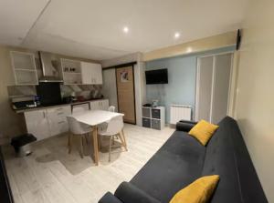a living room with a black couch and a kitchen at Cabana in Mâcon