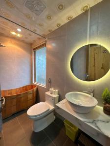 a bathroom with a toilet and a sink and a tub at Én Nhỏ Homestay Sa Pa in Sa Pa