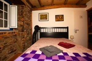 a bedroom with a bed with a purple checkered blanket at Casa da Mata de Fajão in Pampilhosa da Serra