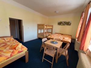 una habitación con dos camas y una mesa y sillas en Apartmány Lipka, en Vimperk