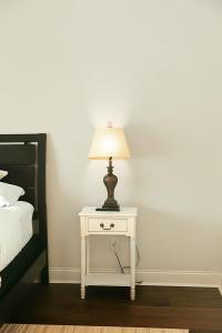 a white table with a lamp on it next to a bed at Spacious Freshly Renovated Townhome - City Side in Loudon +167 photos