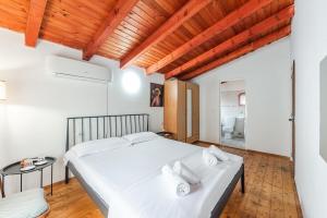 a bedroom with a white bed and a wooden ceiling at 'Easy Steps' Guesthouse - Room 3 - Pro Bono in Shkodër