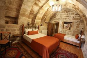 1 dormitorio con 2 camas en una habitación de piedra en Kookaburra Hotel, en Göreme