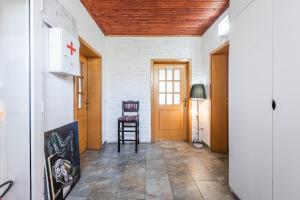 a hallway with a wooden door and a chair at 'Easy Steps' Guesthouse - Room 3 - Pro Bono in Shkodër