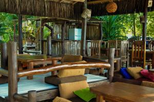 a restaurant with wooden tables and tables and chairs at Pousada Mediterraneo in Barra Grande