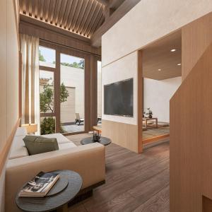 a living room with a couch and a tv at Happy Dragon Courtyard Hotel Beijing Forbidden City Lama Temple in Beijing