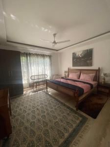 a bedroom with a large bed and a rug at Rural Mitra farms in Noida