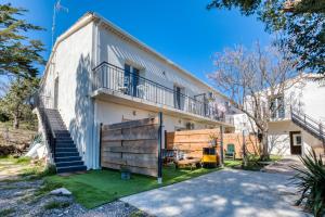 una vista exterior de un edificio blanco con una escalera en Appartement 4 personnes, en Balaruc-le-Vieux