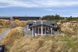a small house in the middle of a field at Feriehus 1103 in Ringkøbing +22 photos