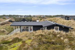 a house with a grass roof on top of a hill at Feriehus 1103 in Ringkøbing