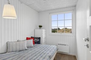 a bedroom with a bed and a window at Feriehus 1103 in Ringkøbing