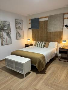 a bedroom with a bed and two tables and two lamps at HOTEL LOS ALAMOS BOUTIQUE in Plasencia
