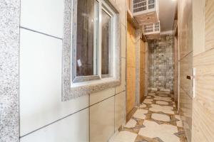 a hallway with a window and a tile floor at Hotel O 7 in Lucknow