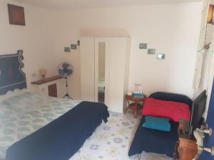 a bedroom with a bed and a desk with a fan at Con i piedi nell'acqua in Stromboli