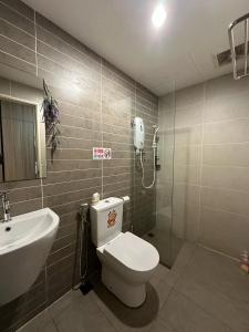 a bathroom with a toilet and a sink and a phone at Cozy Stays Studio C - Kozi Square Kuching in Kuching