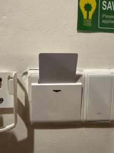 a laptop computer sitting on top of an outlet on a wall at Cozy Stays Studio C - Kozi Square Kuching in Kuching +16 photos