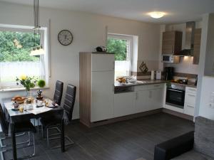 Una cocina con una mesa y un comedor. en Sandperle, Ferienhaus, en Aurich