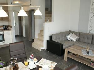 una sala de estar con un sofá y una mesa en Sandperle, Ferienhaus, en Aurich