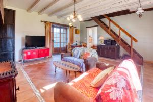 a living room with a couch and a tv at Maison Callen in Festalemps